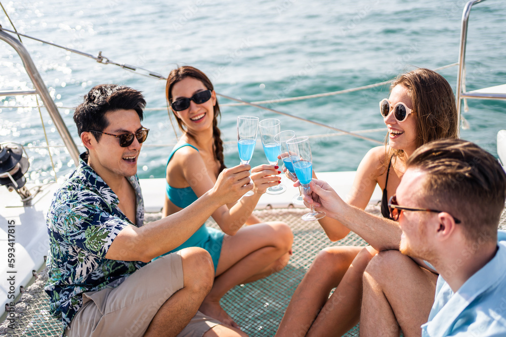 Group of diverse friends drink champagne while having a party in yacht. 