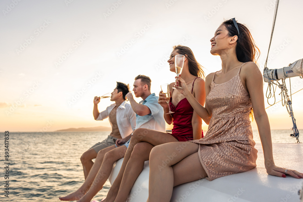 Group of diverse friends drink champagne while having a party in yacht. 