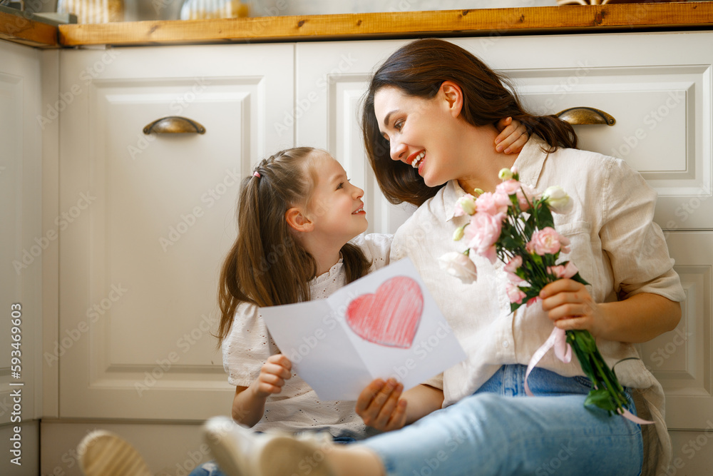 Daughter giving mother bouquet of flowers.