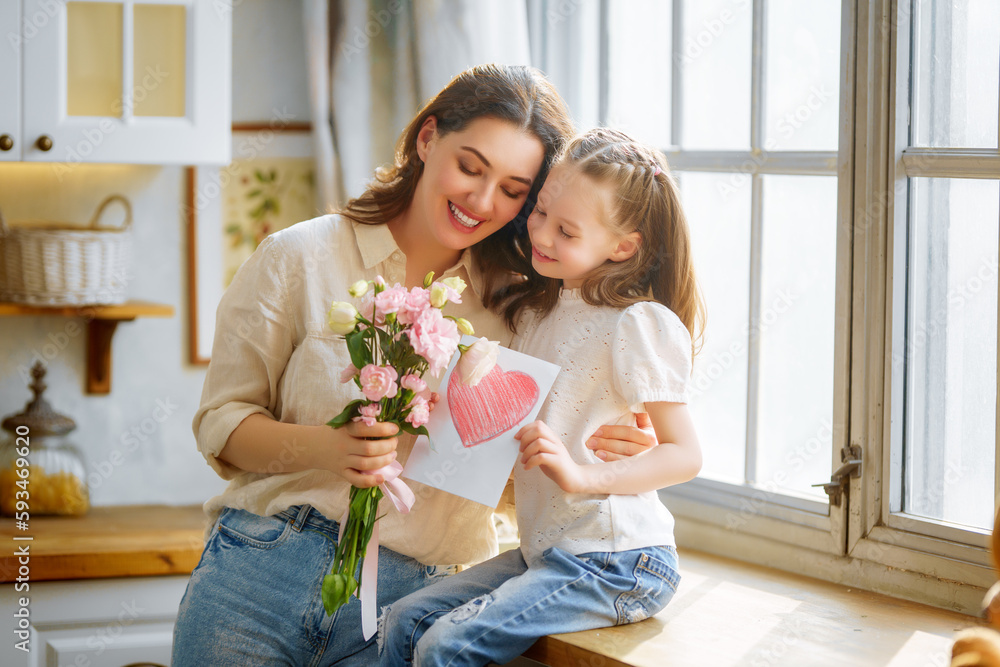 Daughters giving mother bouquet of flowers.