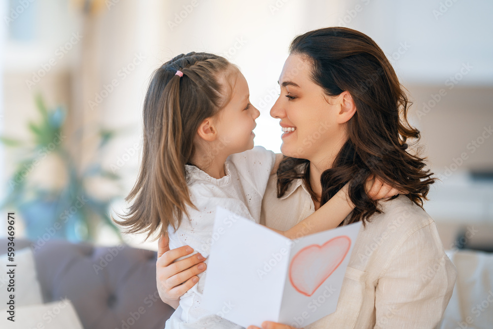 Daughter giving mother bouquet of flowers.