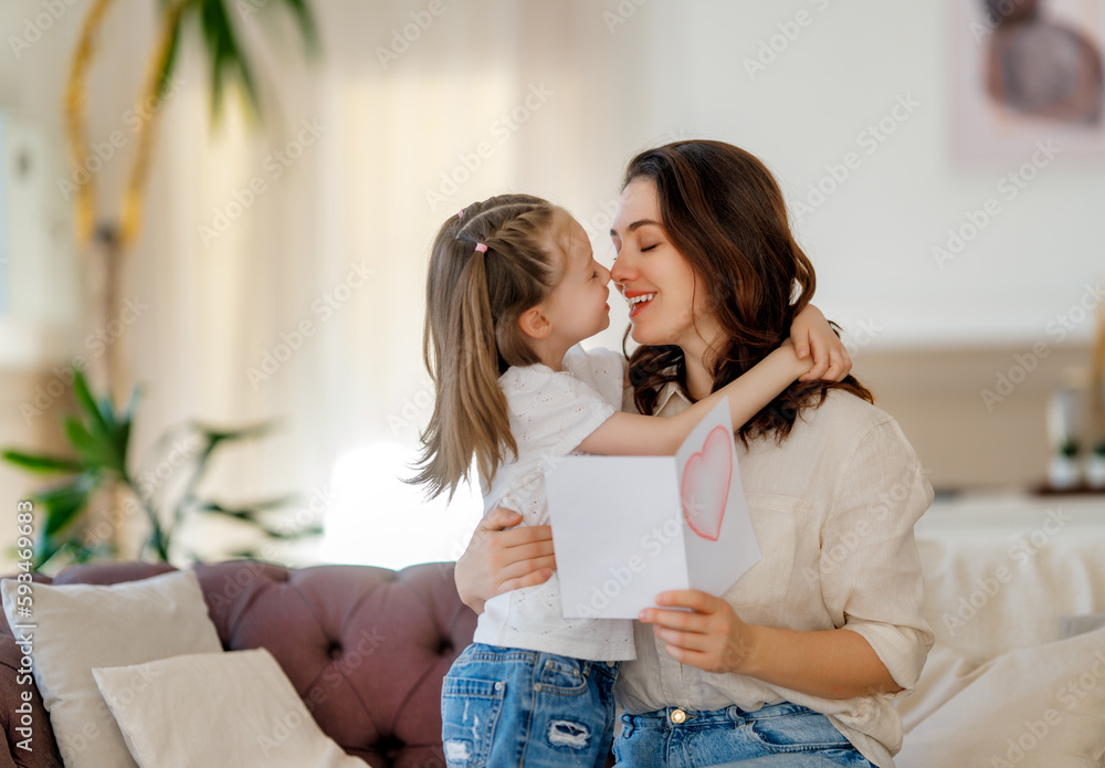 Daughter giving mother bouquet of flowers.