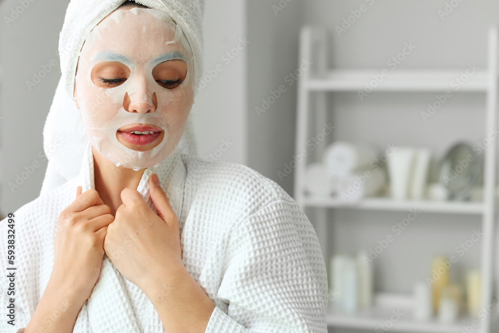 Young woman with sheet mask in bathroom, closeup