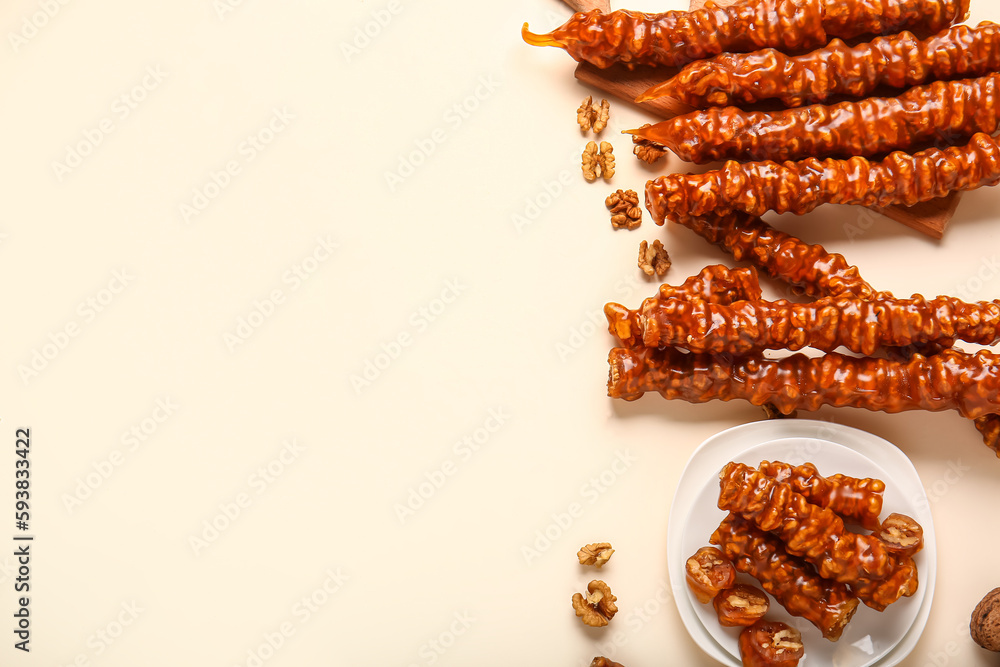 Delicious churchkhela and walnuts on color background