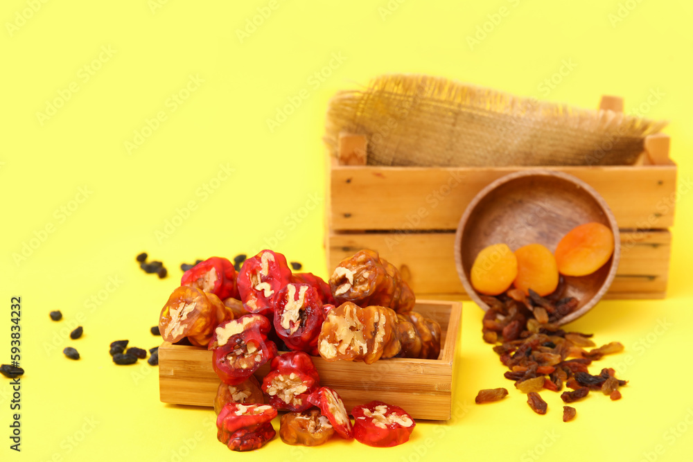 Box with delicious churchkhela and ingredients on yellow background