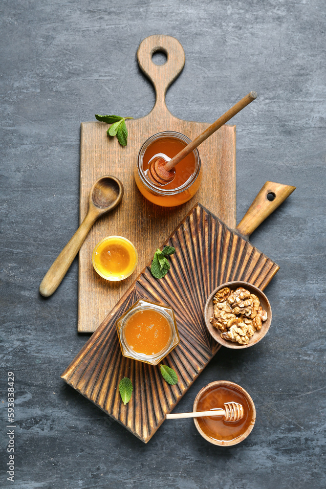 Composition with sweet honey and walnuts on dark background