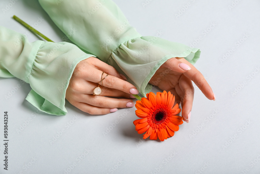 Woman with flower on light background. Hand care concept