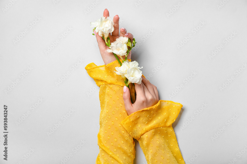 Woman with white flowers on light background. Hand care concept