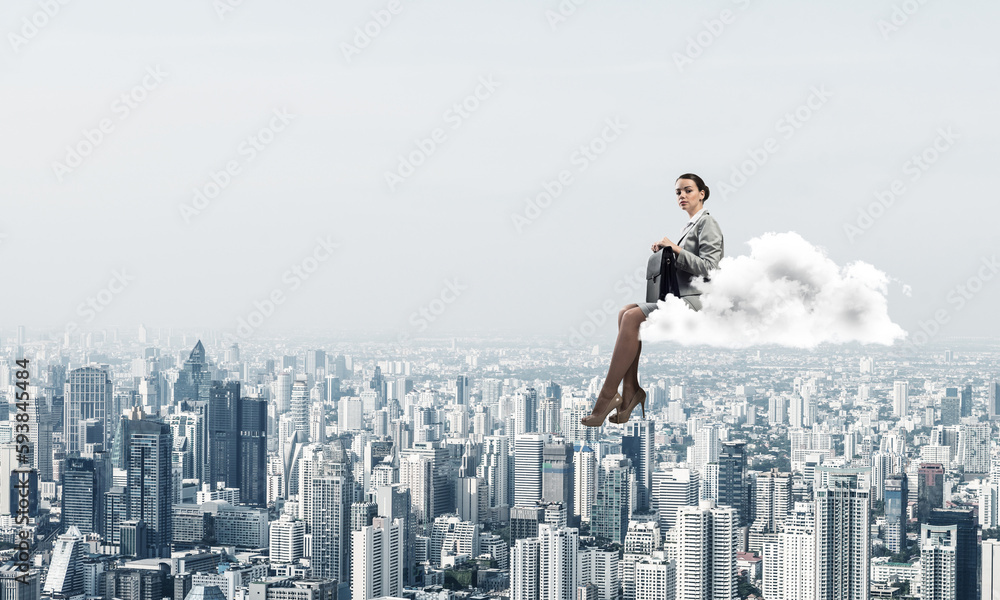 Businesswoman or accountant on cloud floating high above modern city