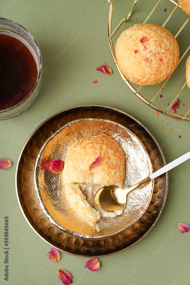 Plates with tasty choux dessert on green background