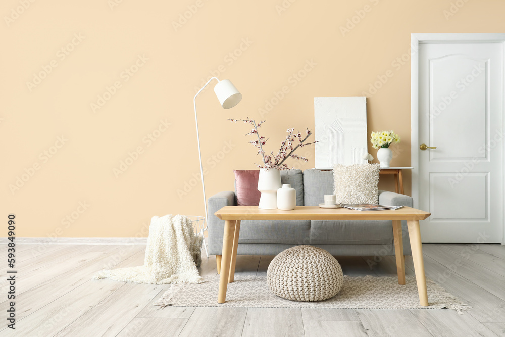 Interior of living room with grey sofa, tables and lamp