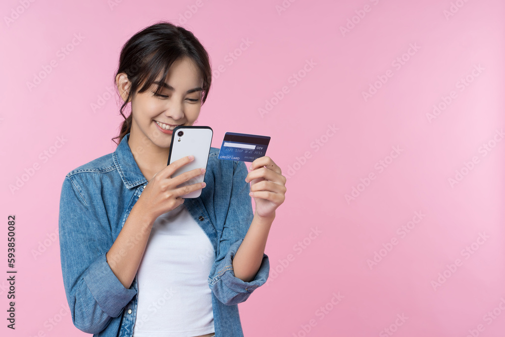 Young beauty Asian woman shopping payment online with credit card on smartphone and she wearing jean