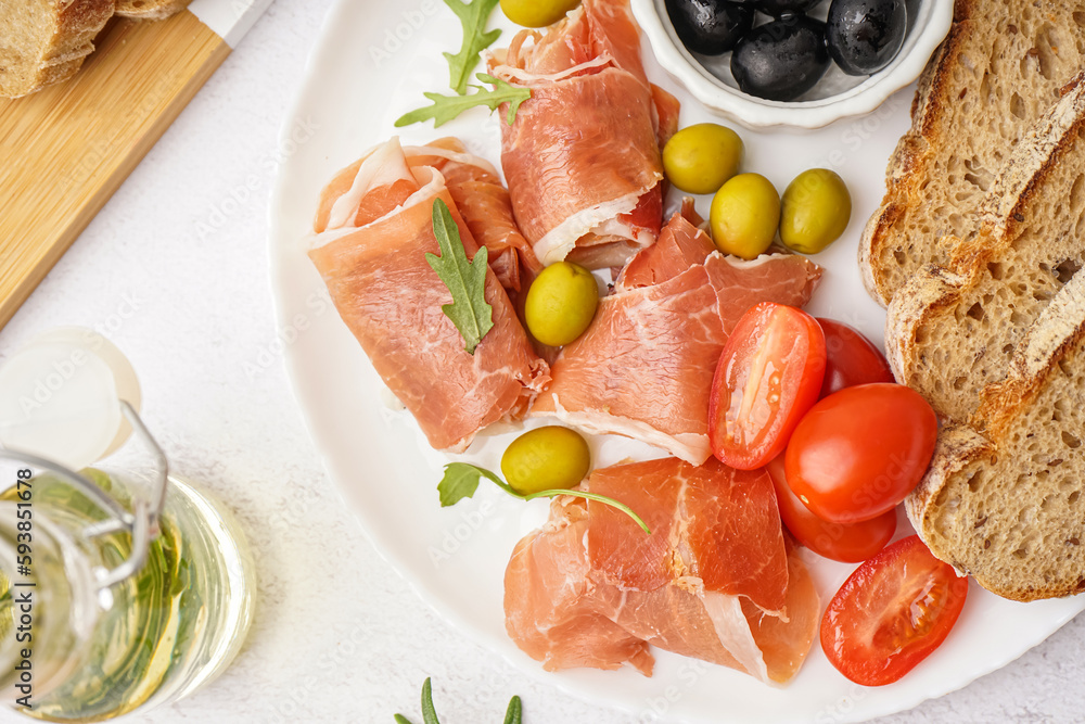 Plate with slices of tasty jamon on light background, closeup