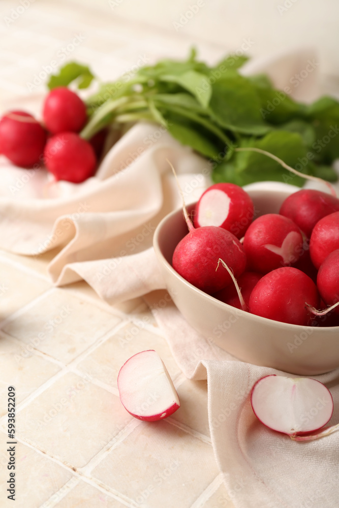 Bowl of ripe radish on light tile background, closeup