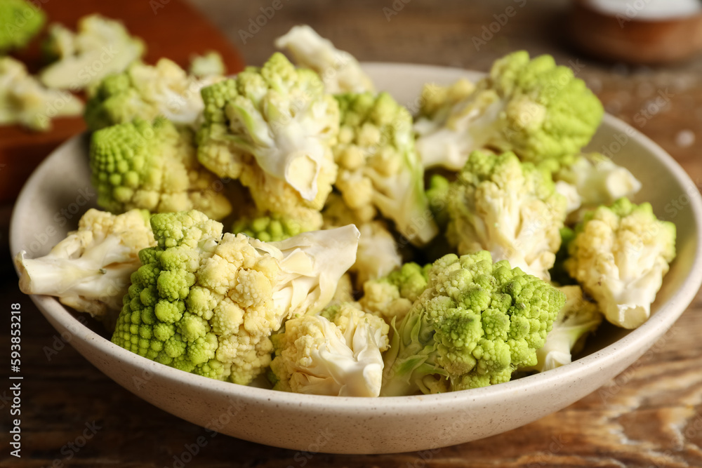 Bowl with baby romanesco cabbage on wooden table