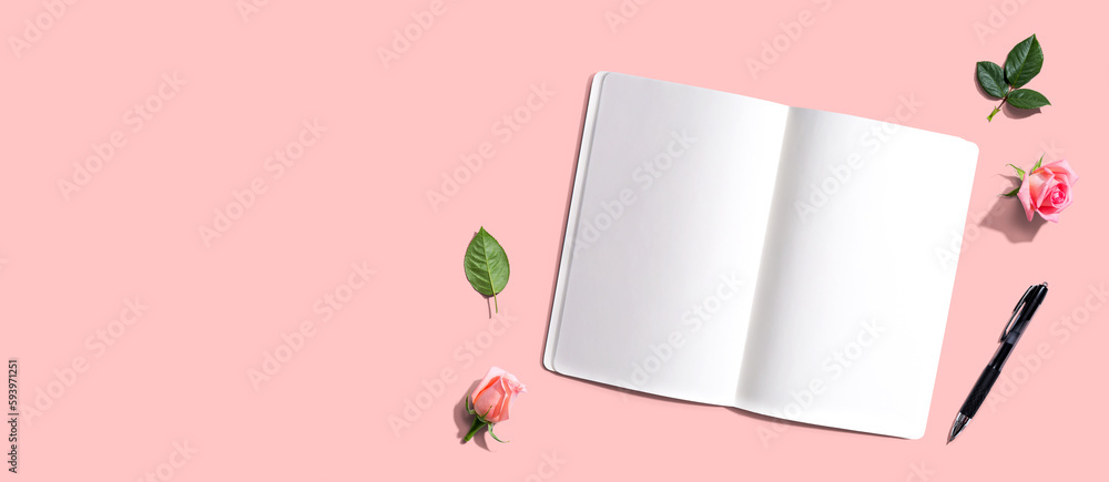 Open notebook or diary with a pen from above with rose buds- flat lay