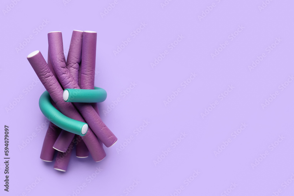 Hair curlers on lilac background