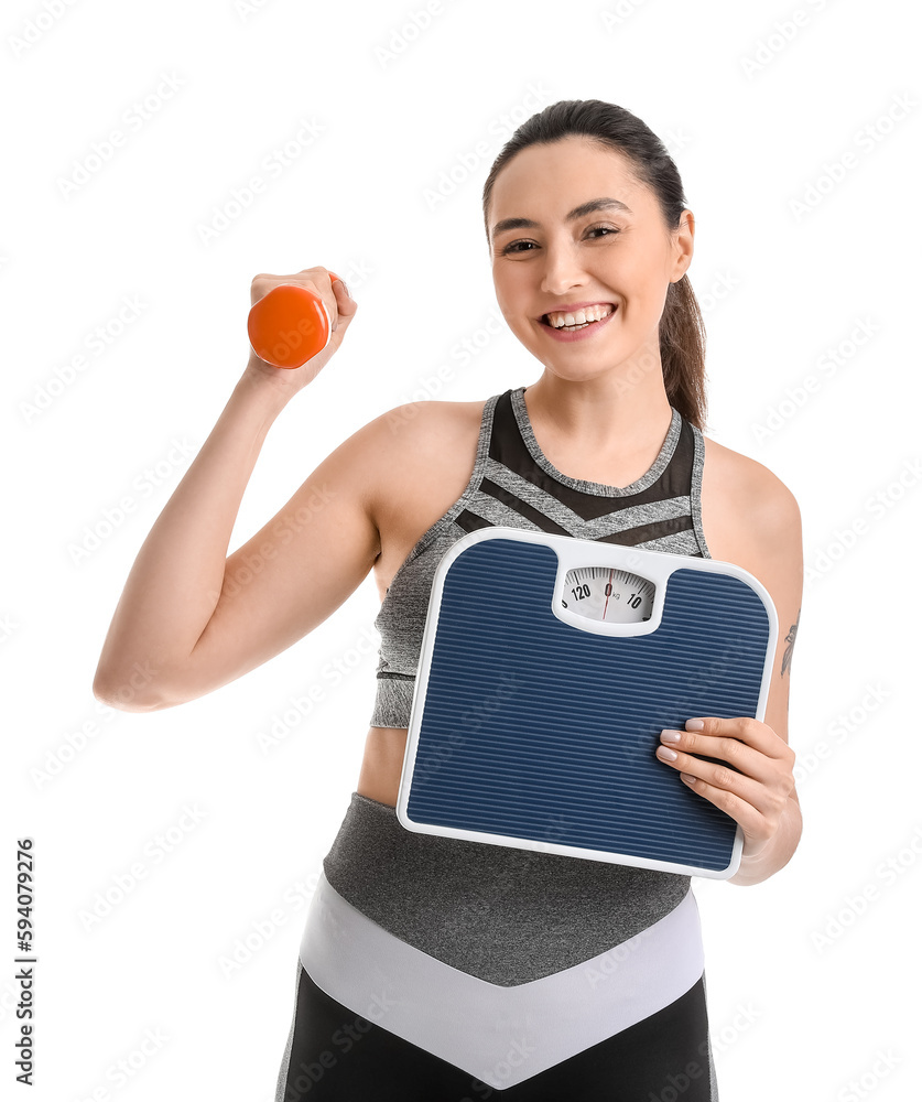 Sporty young woman with scales and dumbbell on white background