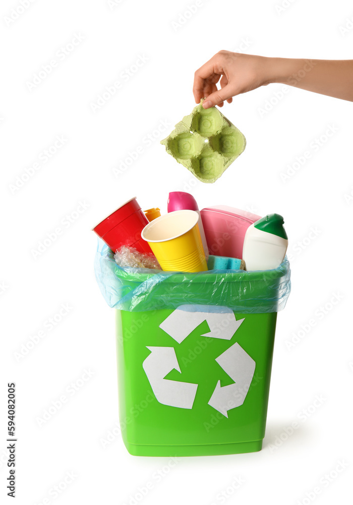 Woman throwing garbage into trash bin on white background