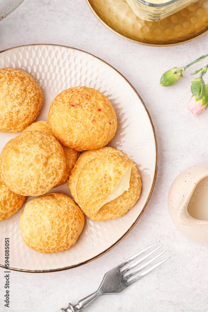 Plate with tasty choux dessert on light background, closeup