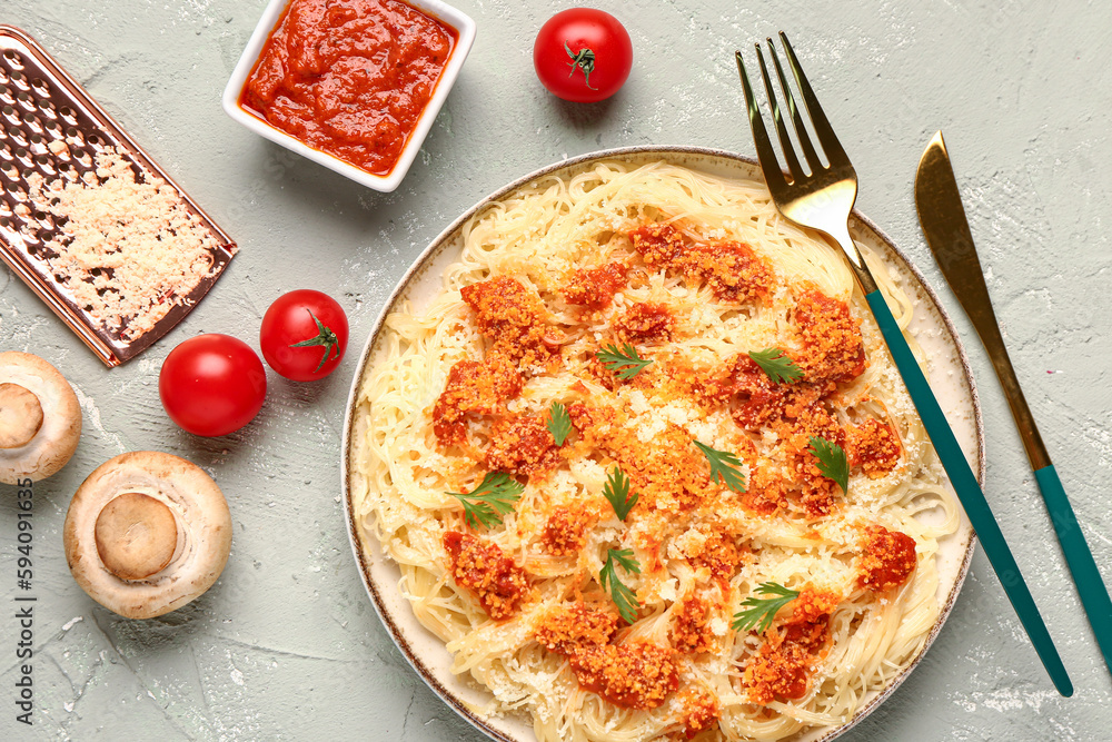 Plate of tasty Italian pasta with Parmesan cheese and ingredients on light background