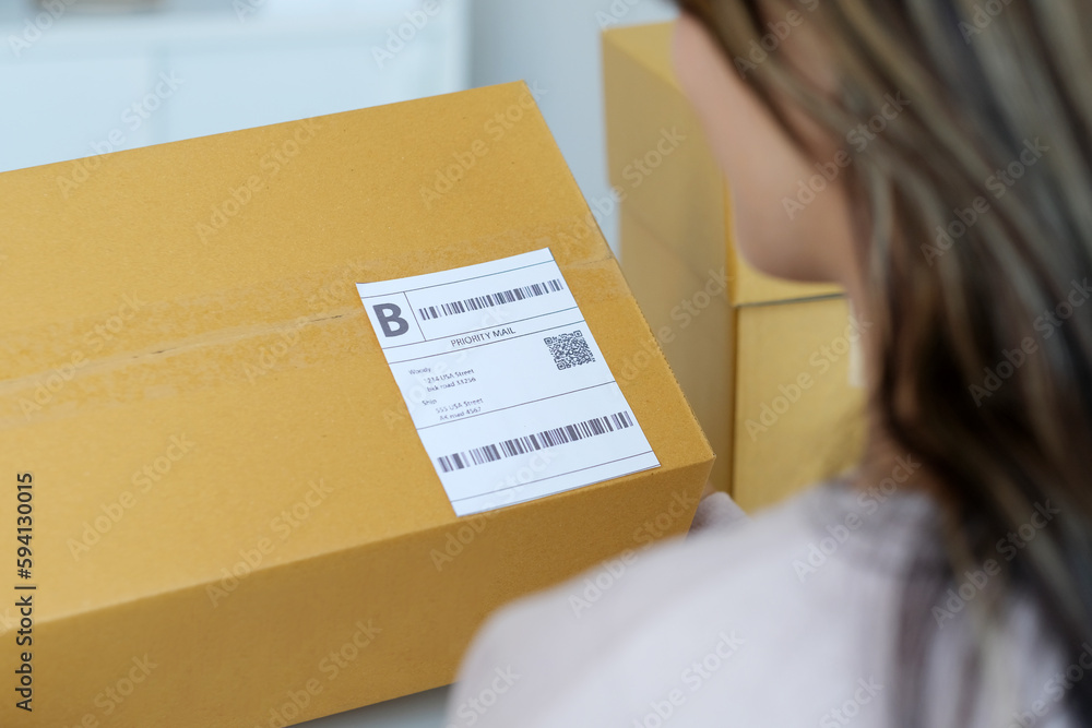 Close up of woman hand holding product box with bar code for delivering to customer, online shopping