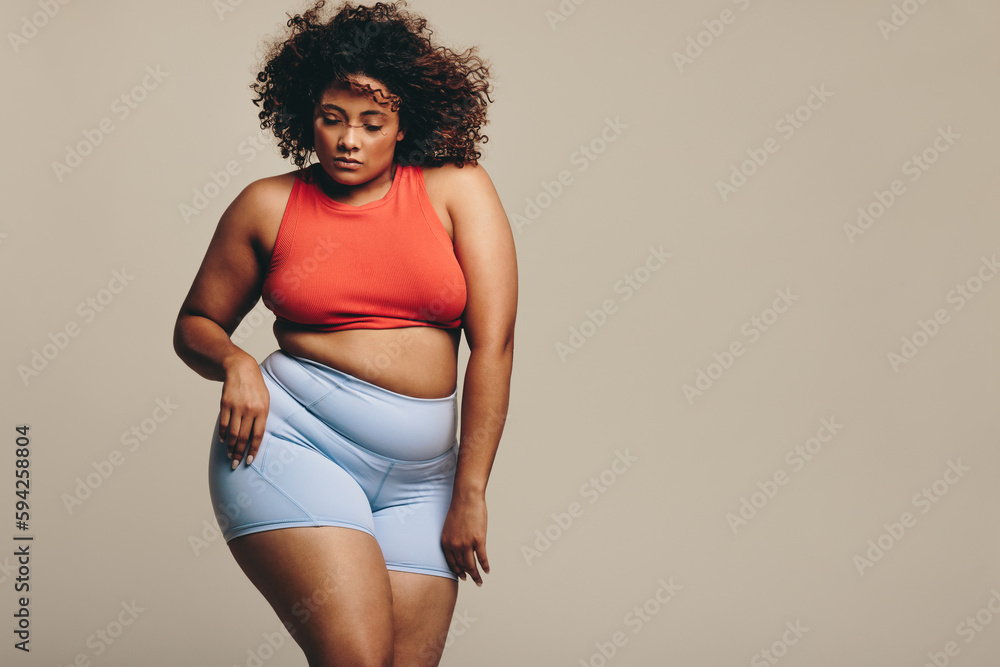 Confident young woman moving her fit and flexible body in a studio