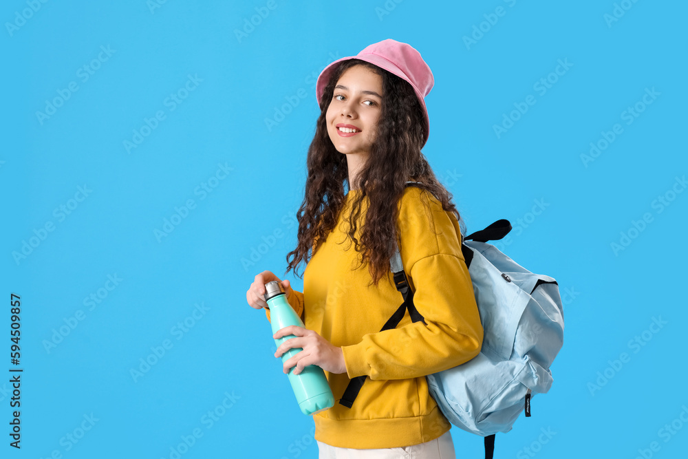 Female student with bottle of water and backpack on blue background