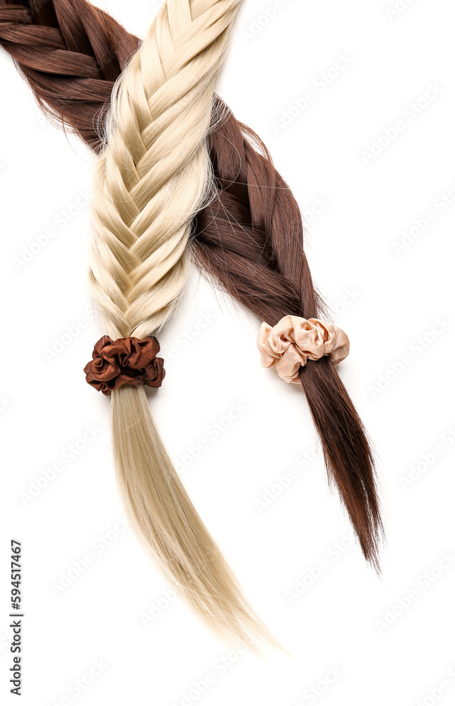 Braided strands with scrunchies on white background, closeup