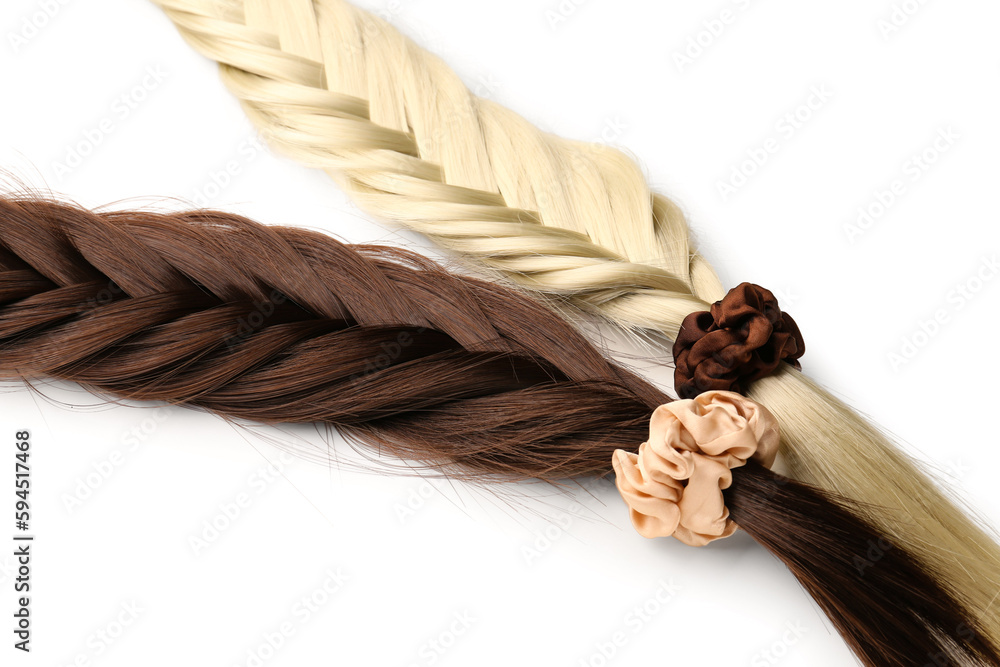 Braided strands with scrunchies on white background, closeup