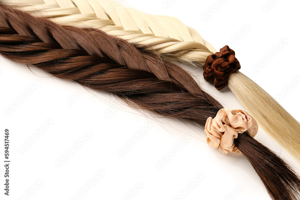 Braided strands with scrunchies on white background, closeup