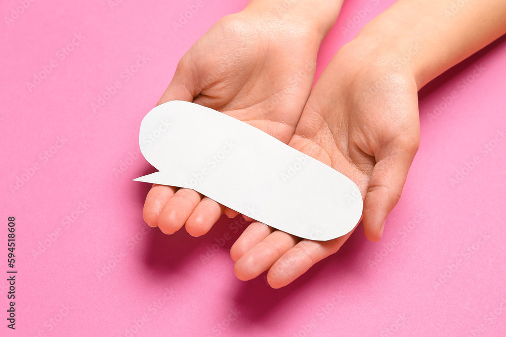 Woman holding blank speech bubble on pink background