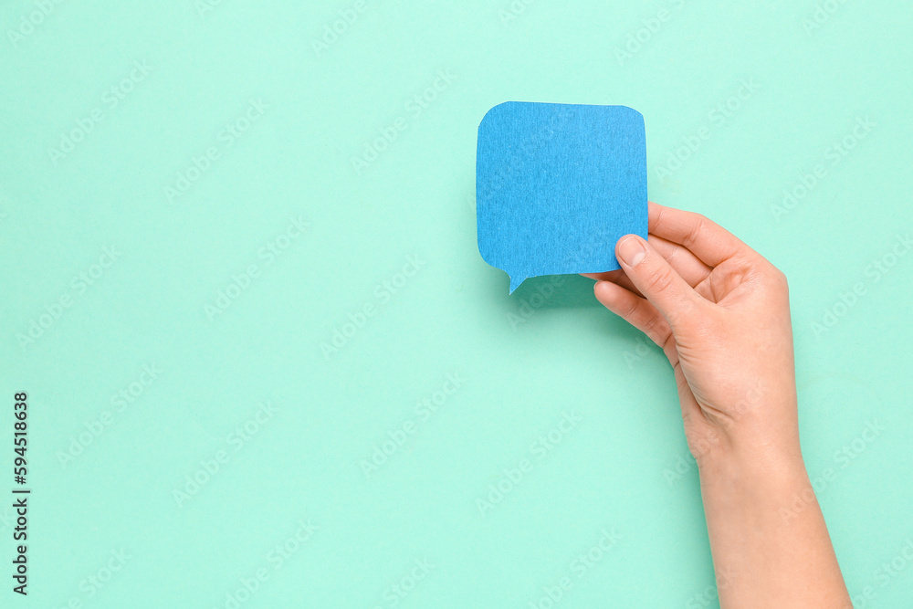 Woman holding blank speech bubble on turquoise background