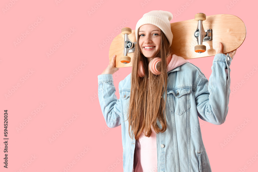 Female student with skateboard on pink background