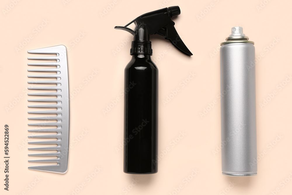 Hair sprays with comb on beige background