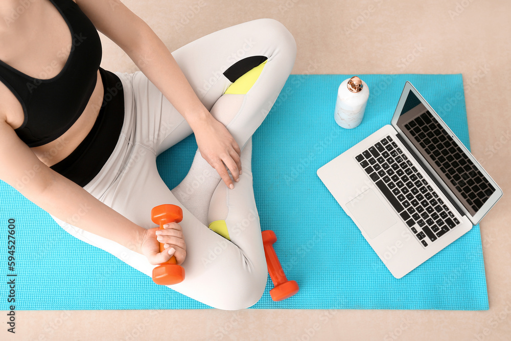 Sporty woman training with dumbbell in gym