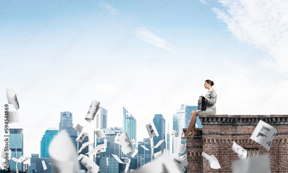 Businesswoman or accountant on brick roof against modern city scape