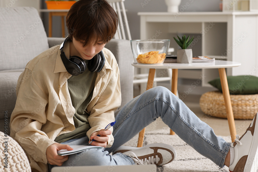 Male student with laptop studying online at home