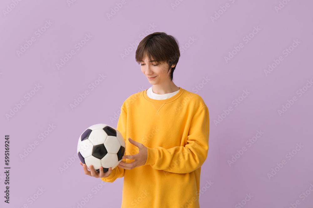 Teenage boy with soccer ball on lilac background