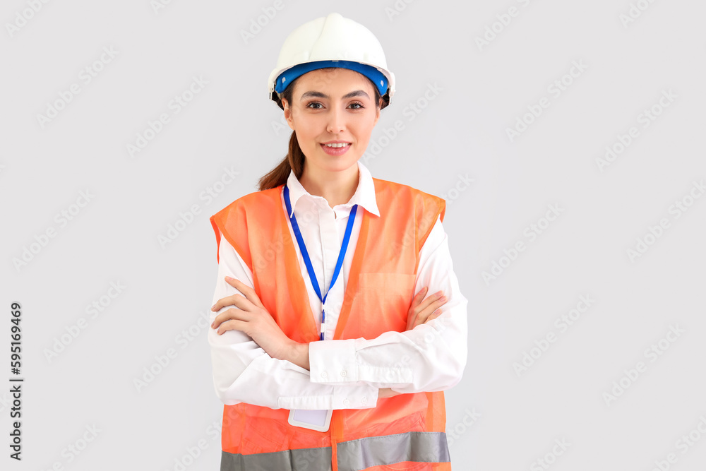 Female worker in vest on light background