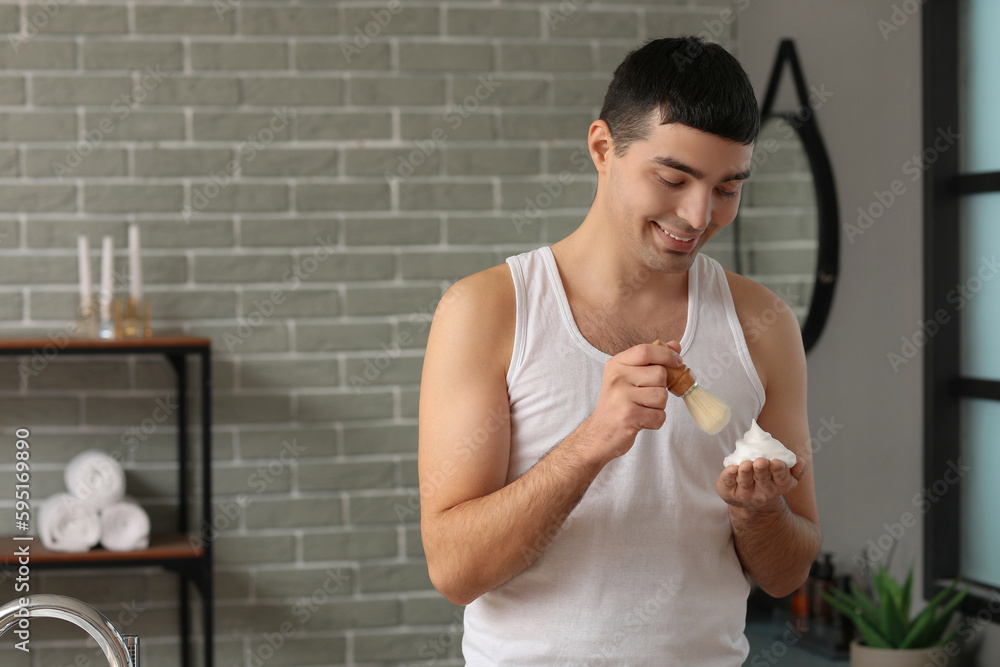 Young man with shaving foam in bathroom