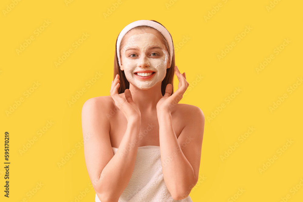 Young woman with applied turmeric mask on yellow background