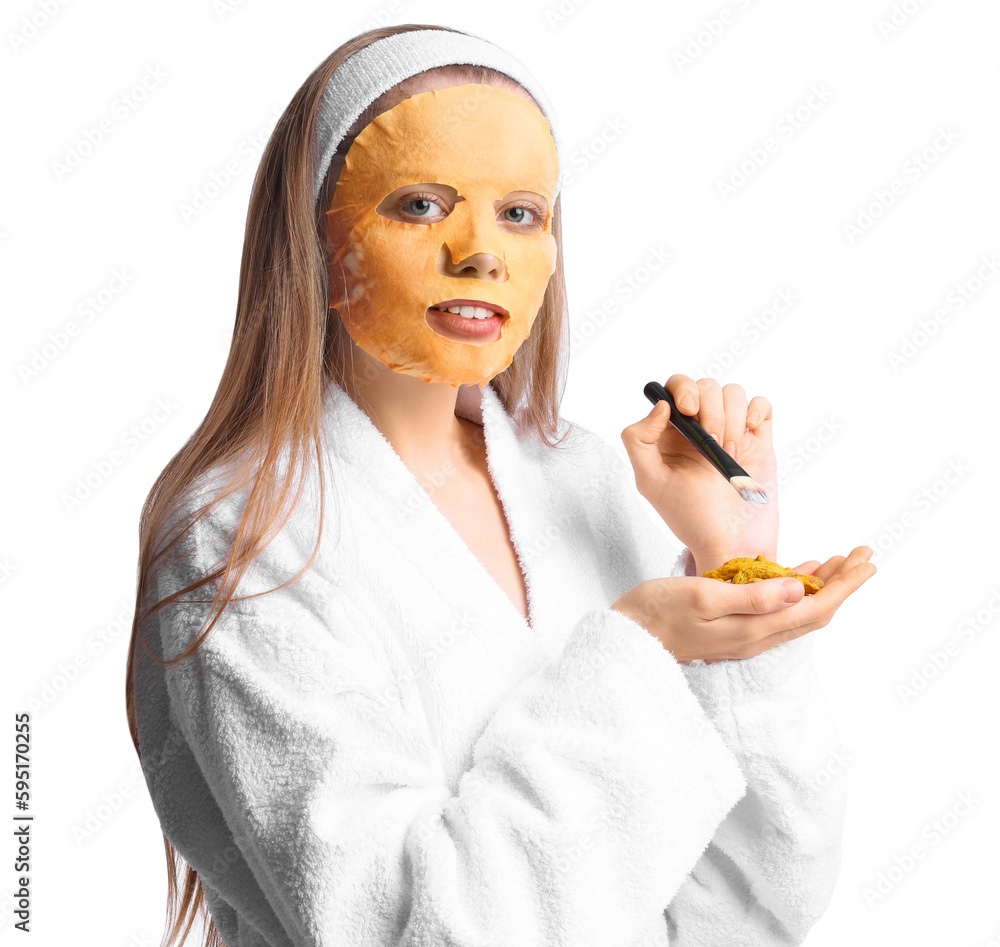 Young woman with turmeric mask, brush and roots on white background