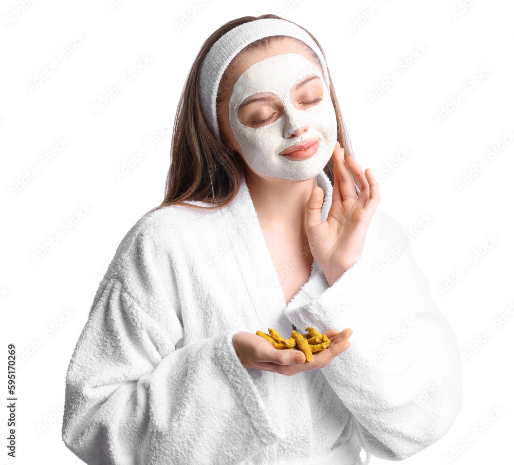 Young woman with applied turmeric mask and roots on white background