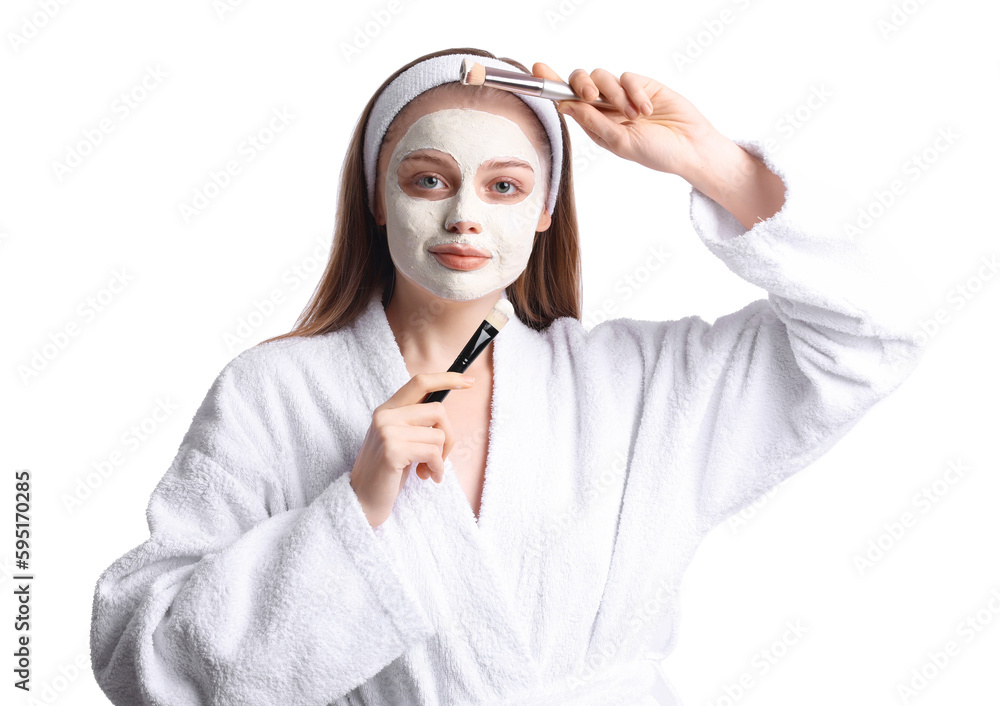 Young woman with applied turmeric mask and brushes on white background