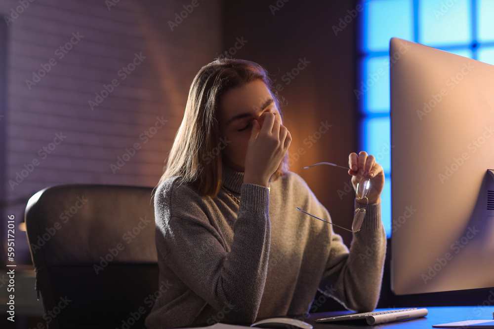 Tired female programmer working in office at night