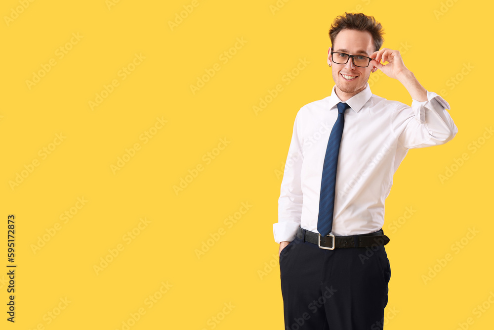 Young businessman on yellow background