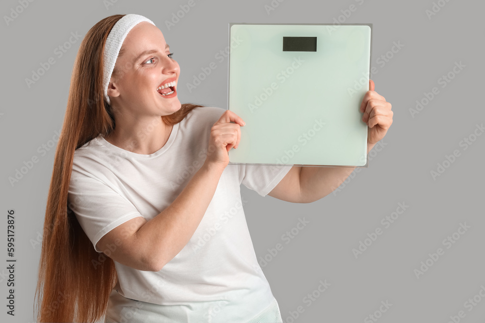 Young overweight woman with scales on grey background