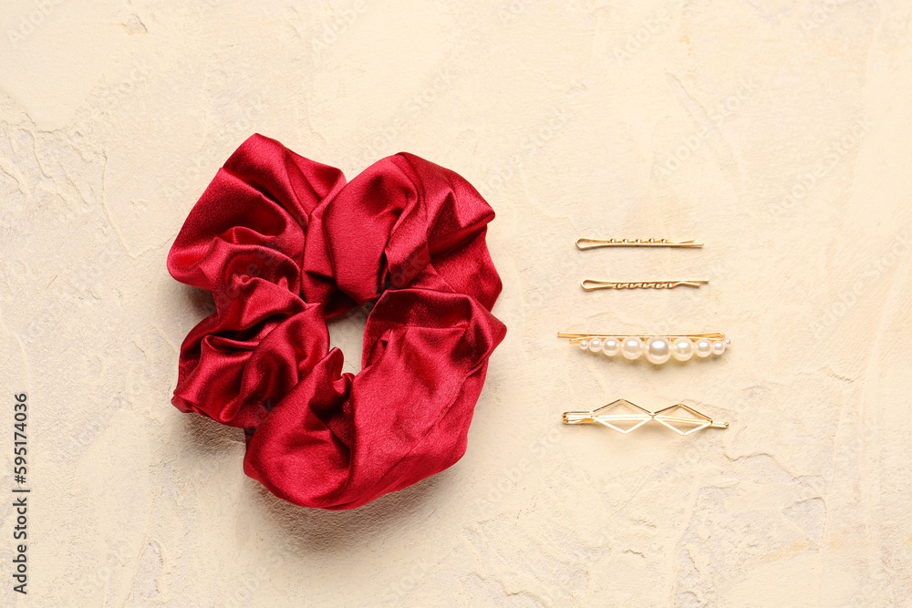 Stylish scrunchy and different hairpins on color background