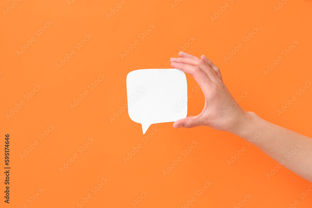 Woman holding blank speech bubble on orange background